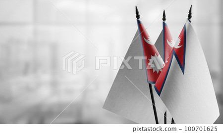 Small flags of the Nepal on an abstract blurry background Small flags of the Nepal on an abstract blurry background 100701625
