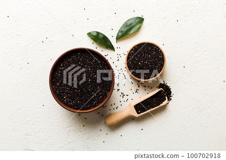 quinoa seeds in bowl and spoon on colored background. Healthy kinwa in small bowl. Healthy superfood quinoa seeds in bowl and spoon on colored background. Healthy kinwa in small bowl. Healthy superfood 100702918