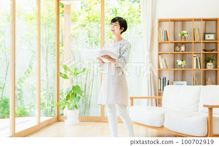 Young woman doing housework in the living room Young woman doing housework in the living room 100702919