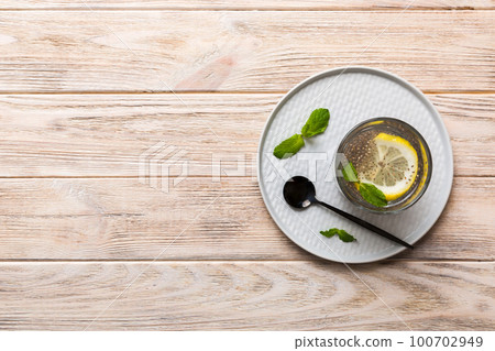 Healthy breakfast or morning with chia seeds lemon and mint on table background, vegetarian food, diet and health concept. Chia pudding with lemon and mint 100702949
