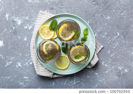 Healthy breakfast or morning with chia seeds lemon and mint on table background, vegetarian food, diet and health concept. Chia pudding with lemon and mint 100702950