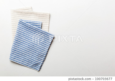 top view with blue kitchen napkin isolated on table background. Folded cloth for mockup with copy space, Flat lay. Minimal style top view with blue kitchen napkin isolated on table background. Folded cloth for mockup with copy space, Flat lay. Minimal style 100703677