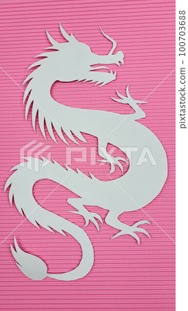 Paper white dragon on pink corrugated paper background. The concept of the new year. Paper white dragon on pink corrugated paper background. The concept of the new year. 100703688