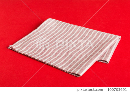 top view with red empty kitchen napkin isolated on table background. Folded cloth for mockup with copy space, Flat lay. Minimal style top view with red empty kitchen napkin isolated on table background. Folded cloth for mockup with copy space, Flat lay. Minimal style 100703691