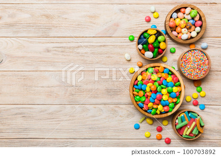 different colored round candy in bowl and jars. Top view of large variety sweets and candies with copy space 100703892