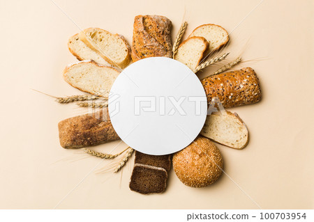 Minimalist paper blank mockup on background of Types of homemade bread. Different kinds of fresh bread as background, top view with space for your text or design Minimalist paper blank mockup on background of Types of homemade bread. Different kinds of fresh bread as background, top view with space for your text or design 100703954