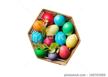 Basket of colorful Easter eggs isolated on white background. Easter basket filled with colored eggs top view holiday concept Basket of colorful Easter eggs isolated on white background. Easter basket filled with colored eggs top view holiday concept 100703989