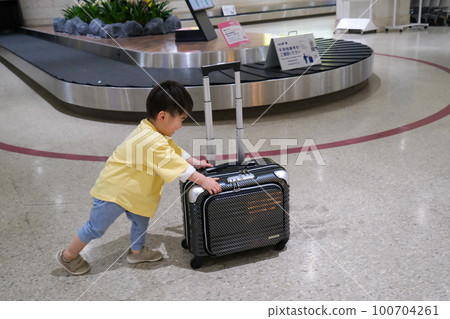 Boy pushing a suitcase Travel image 100704261