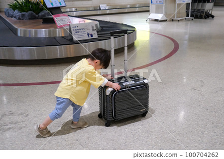 Boy pushing a suitcase Travel image 100704262