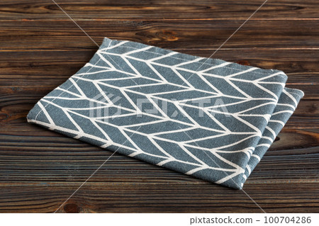 top view with blue kitchen napkin isolated on table background. Folded cloth for mockup with copy space, Flat lay. Minimal style top view with blue kitchen napkin isolated on table background. Folded cloth for mockup with copy space, Flat lay. Minimal style 100704286