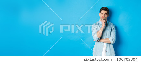 Image of adult bearded man 25s years, thinking about something, looking at upper left corner and pondering ideas, standing over blue background Image of adult bearded man 25s years, thinking about something, looking at upper left corner and pondering ideas, standing over blue background 100705304
