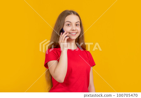 cheerful girl with smartphone on yellow background 100705470