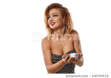 Ginger girl in gray dress posing holding a lot of colorful chips in her palms standing isolated on white background. Casino, poker. Close-up shot. Ginger girl in gray dress posing holding a lot of colorful chips in her palms standing isolated on white background. Casino, poker. Close-up shot. 100705619