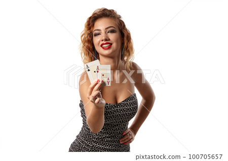 Ginger girl wearing gray dress is posing holding two playing cards in her hands standing isolated on white background. Casino, poker. Close-up shot. 100705657