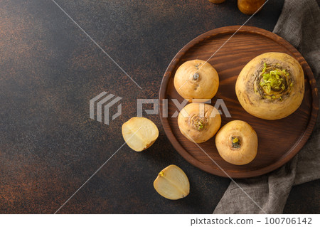 Yellow turnip with stems for cooking. Autumn harvest of root vegetables. 100706142