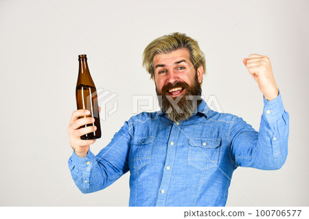 happy man hold full glass bottle in hand. male holding bottle of beer. hipster rest in pub. Sports lover cheer up. mature man holding glass bottle of beer. drunk hipster male craft bottled beer 100706577