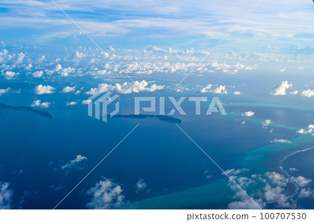 Blue sky with white clouds seen through airplane window 100707530