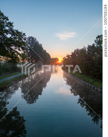 Aerial view of a colorful dramatic sunrise sky over a canal in Belgium. Canals with water for Aerial view of a colorful dramatic sunrise sky over a canal in Belgium. Canals with water for 100708184
