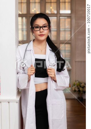 Portrait of female doctor with a stethoscope in white uniform standing in a hospital. 100710017