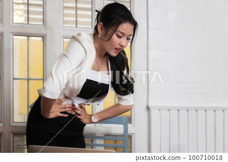Business woman have stomachache from gastritis. Because she is busy working, eating too late. 100710018
