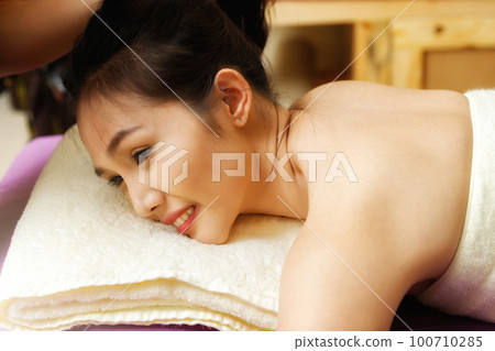 Asian woman enjoying back massage in massage salon. Beauty treatment concept. 100710285