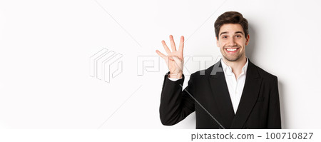 Close-up of handsome businessman in black suit, smiling amazed, showing number four, standing over white background Close-up of handsome businessman in black suit, smiling amazed, showing number four, standing over white background 100710827
