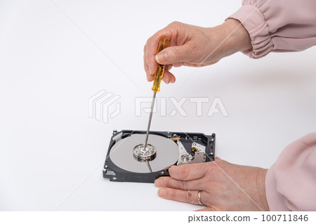[Woman disassembling HDD with a screwdriver] 100711846