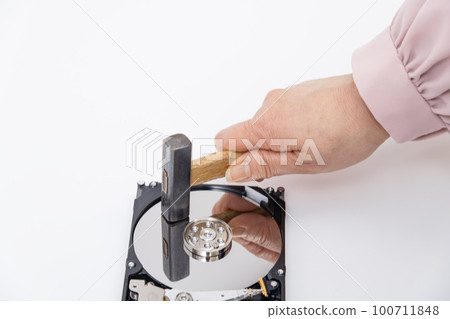 [Woman destroying HDD with a hammer] 100711848