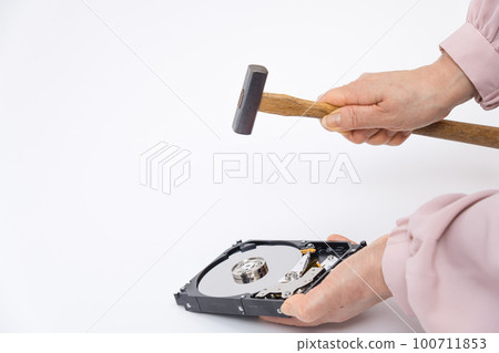 [Woman destroying HDD with a hammer] 100711853
