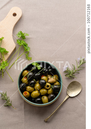 Black and green olives in a bowl. Delicious, marinated olives. Top view. 100712168