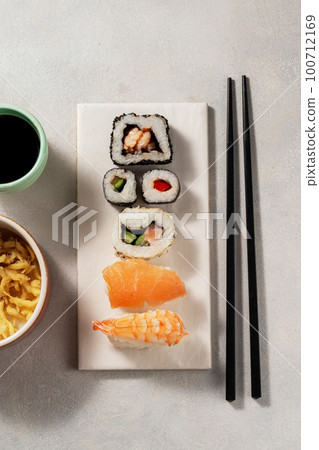 Homemade sushi rolls with salmon, shrimp, avocado. Served with soy sauce and ginger. Homemade sushi rolls with salmon, shrimp, avocado. Served with soy sauce and ginger. 100712169