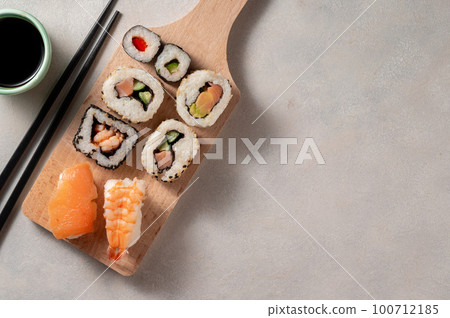 Homemade sushi rolls with salmon, shrimp, avocado. Served with soy sauce and ginger. 100712185