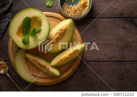 Cantaloupe, melon fruit slice over dark background. Healthy snack or dessert, copy space 100712228