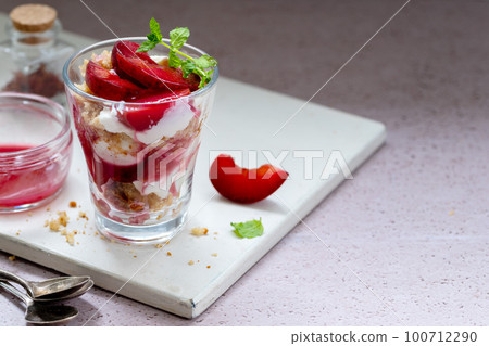 Trifles in layers with red plums and whipped cream homemade dessert Trifles in layers with red plums and whipped cream homemade dessert 100712290