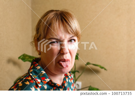 Woman procrastinate at home workplace. Playful woman sticking out tongue in office. Funny face concept. Businesswoman sticking out her tongue and showing. Out of focus Woman procrastinate at home workplace. Playful woman sticking out tongue in office. Funny face concept. Businesswoman sticking out her tongue and showing. Out of focus 100713735