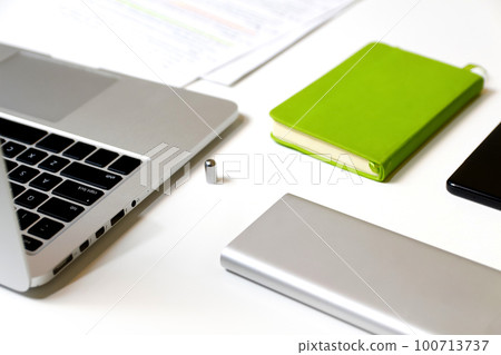 White workplace. Stylish workspace with laptop computer, office supplies, green notebook at office. Desk work concept. Out of focus 100713737