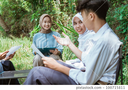 the teacher watches as one of the students is presenting 100715811