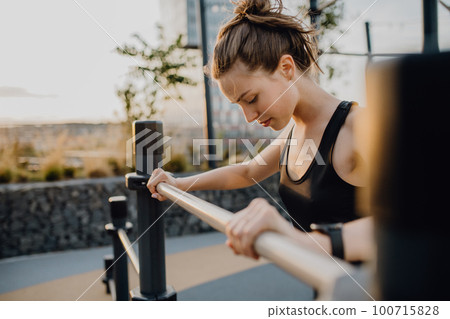 Young woman doing exercises at outdoor work-out city park. Young woman doing exercises at outdoor work-out city park. 100715828