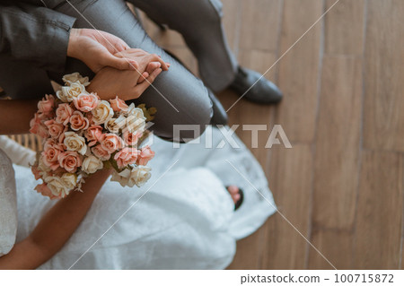 asian brides sitting on the chair together and holding hand asian brides sitting on the chair together and holding hand 100715872