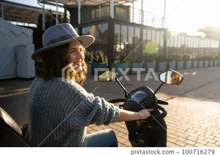 Woman tourist riding a four wheel mobility electric scooter  100716279