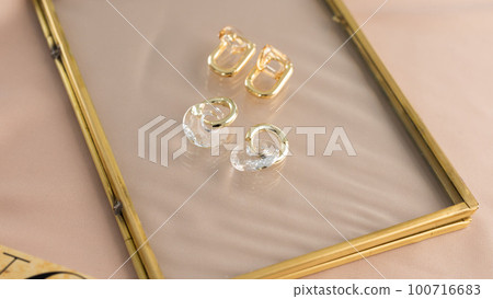 Elegant jewelry set of gold earrings. Jewelry set minimalist style. Handmade bijouterie concept. Elegant jewelry set of gold earrings. Jewelry set minimalist style. Handmade bijouterie concept. 100716683