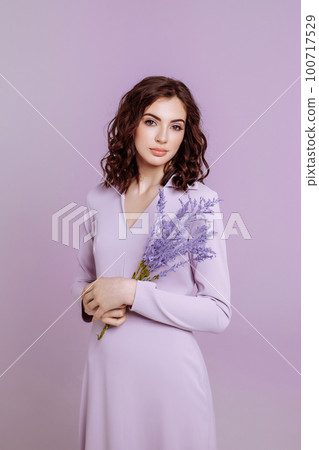 Attractive woman with bouquet on lilac background Attractive woman with bouquet on lilac background 100717529