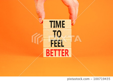 Time to feel better symbol. Concept words Time to feel better on wooden block. Beautiful orange table orange background. Businessman hand. Motivational business time to feel better concept. Copy space Time to feel better symbol. Concept words Time to feel better on wooden block. Beautiful orange table orange background. Businessman hand. Motivational business time to feel better concept. Copy space 100719435