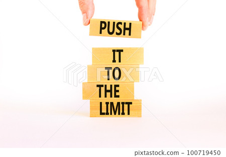 Push it to the limit symbol. Concept words Push it to the limit on wooden blocks. Beautiful white table white background. Businessman hand. Business push it to the limit concept. Copy space. Push it to the limit symbol. Concept words Push it to the limit on wooden blocks. Beautiful white table white background. Businessman hand. Business push it to the limit concept. Copy space. 100719450
