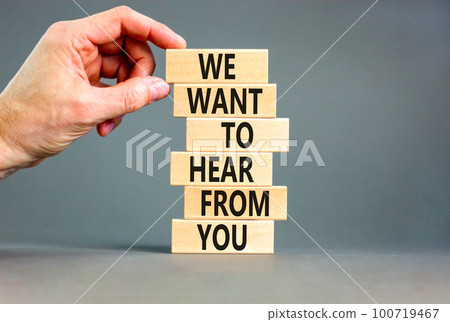 Support symbol. Concept words We want to hear from you on wooden blocks. Beautiful grey table grey background. Businessman hand. Business support we want to hear from you concept. Copy space. 100719467