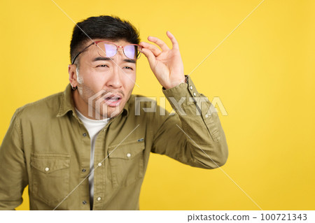 Chinese man taking off her glasses to see far away Chinese man taking off her glasses to see far away 100721343