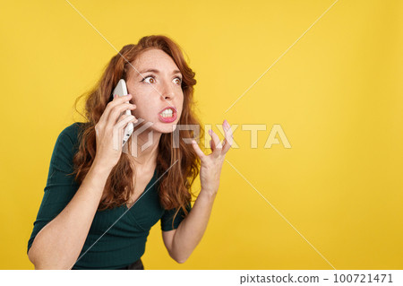 Angry redheaded woman talking to the mobile 100721471