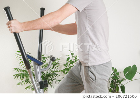 A man trains on an Elliptical Machine. Sports 100721500