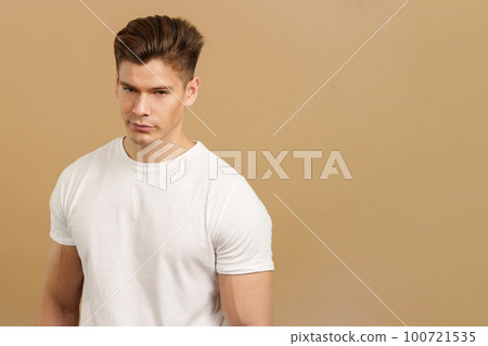 Seductive man looking at camera while standing Seductive man looking at camera while standing 100721535