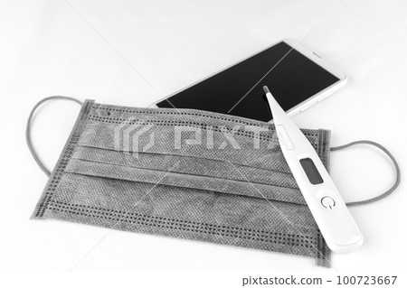 Smartphone, mask and thermometer. Image of a smartphone infected with a virus 100723667